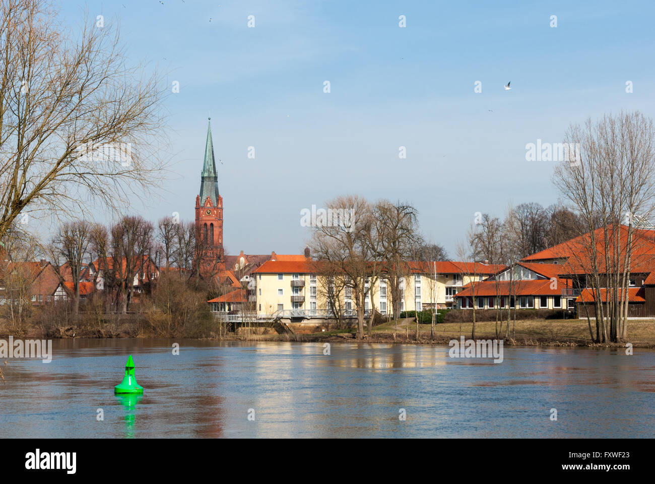 Stadtbild von Nienburg mit Kirchturm, Häuser, Wall und Weser, gesehen vom gegenüberliegenden Ufer des Flusses Weser Stockfoto