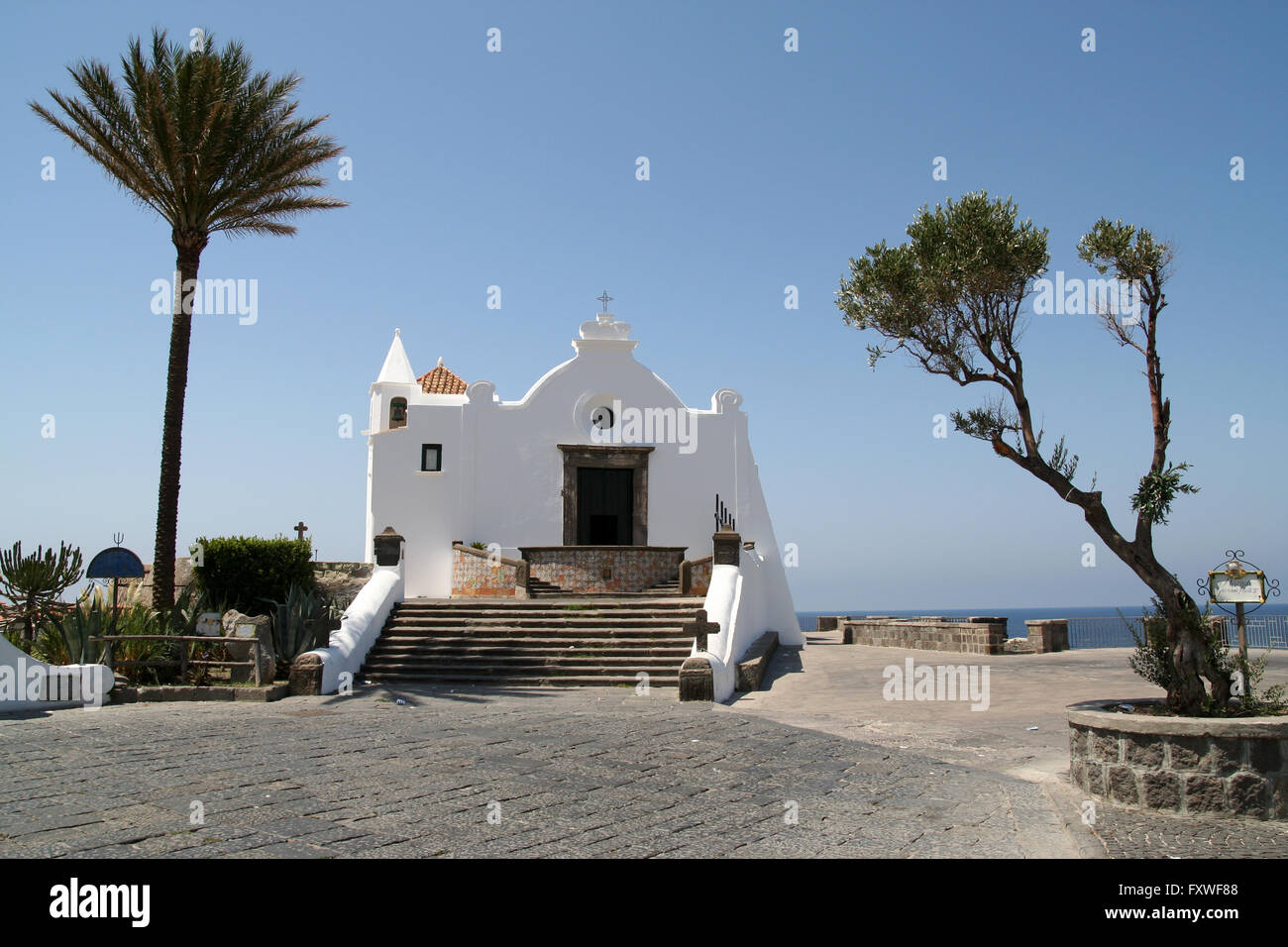 Des Fischers Kapelle am Punta del Soccorso, Forio, auf der Insel Ischia, Italien. Schöne kleine Kapelle umrahmt von zwei Bäume. Stockfoto