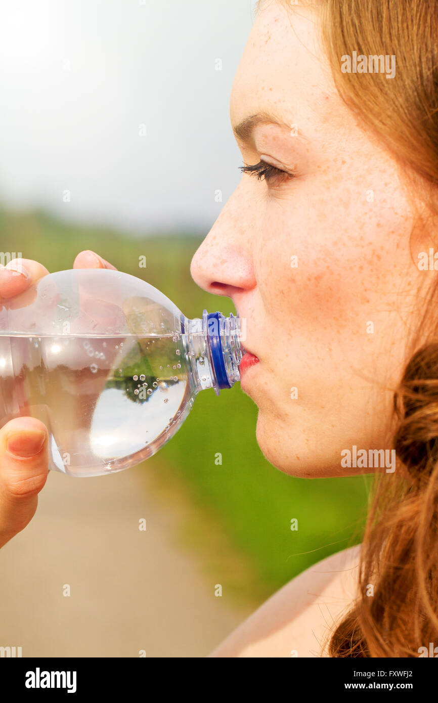 Porträt der jungen Frau trinken Wasser an einem warmen Tag Stockfoto
