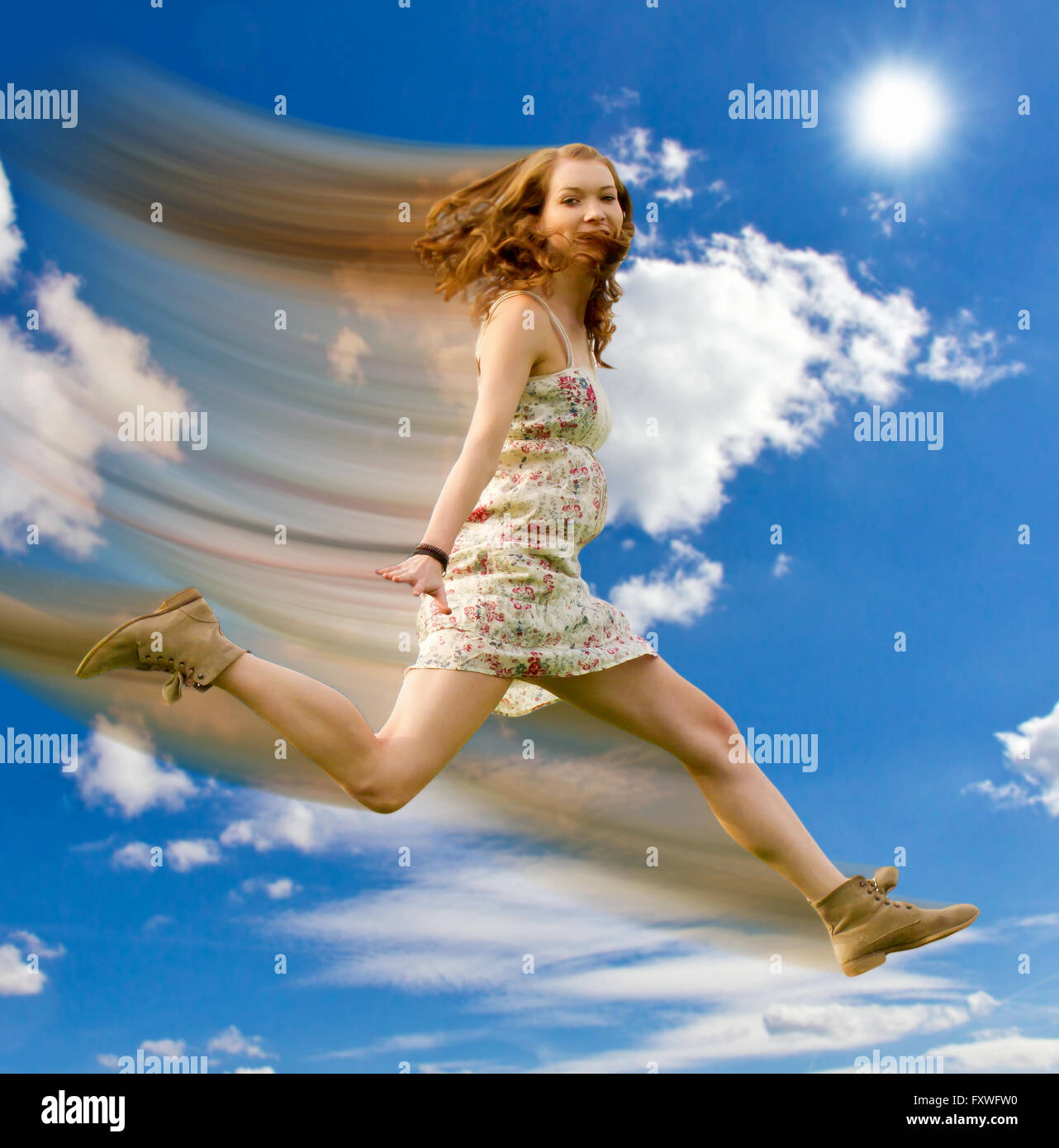 Junge Frau im blauen Himmel springen Stockfoto