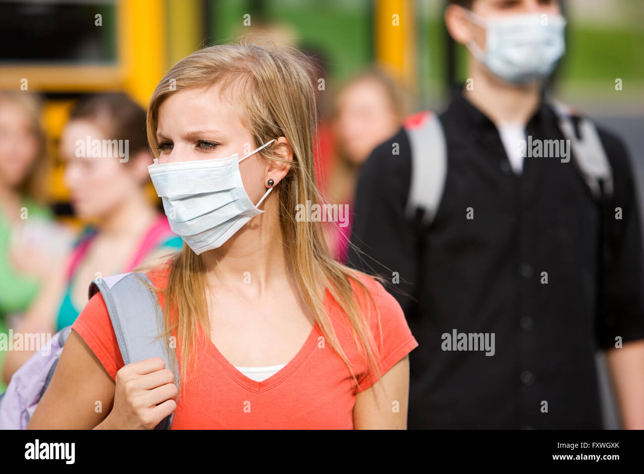 Serie mit multi-ethnischen Gruppe von Jugendlichen Studenten einsteigen und auf einen Schulbus. Bildern, die mit dem tragen Gesichtsmasken zu vermeiden Stockfoto