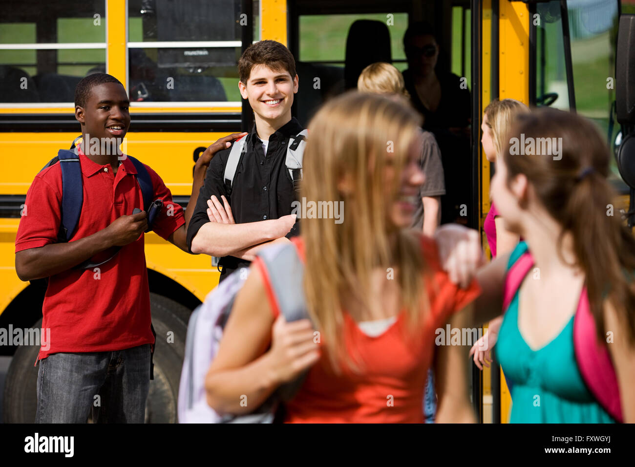 Serie mit multi-ethnischen Gruppe von Jugendlichen Studenten einsteigen und auf einen Schulbus. Stockfoto