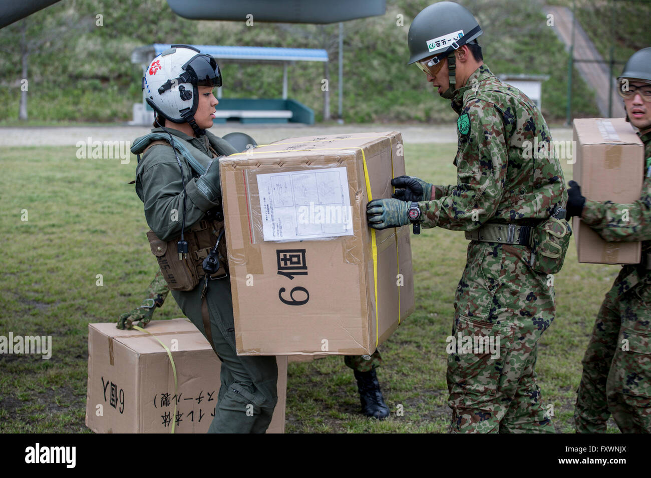 US Marines unterstützen japanische Selbstverteidigung Soldaten entladen humanitäre Hilfe für die betroffenen durch die jüngsten Erdbeben in Kumamoto 18. April 2016 Takayubaru, Japan. Die USA trat Tausende von japanischen Truppen, Opfer von zwei massiven Erdbeben zu helfen, die die Kyushu-Region getroffen. Stockfoto