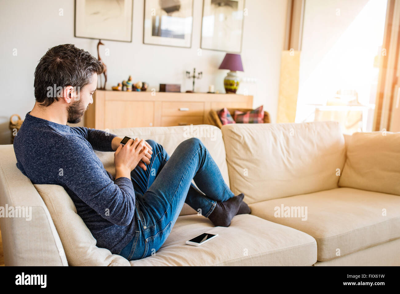 Mann zu Hause sitzen auf Sofa mit smart-watch Stockfoto
