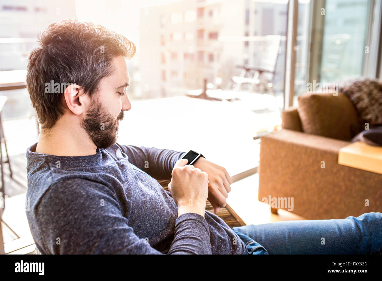 Mann von zu Hause aus mit smart-Watch, Wohnzimmer Stockfoto