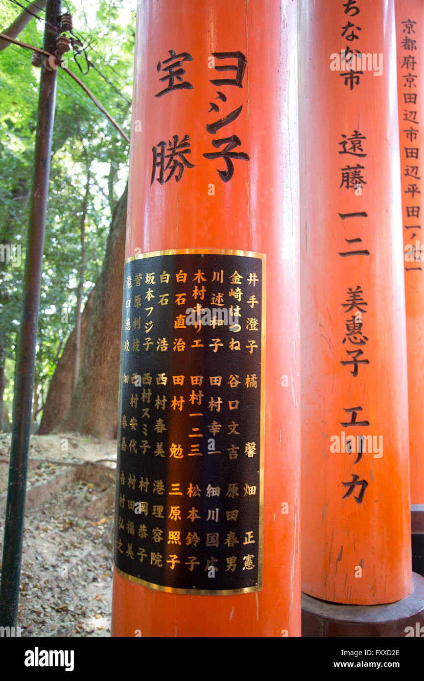 Japanische Inschrift auf einer orange Spalten der Fushimi Inari-Schrein in Kyōto, Japan. Stockfoto