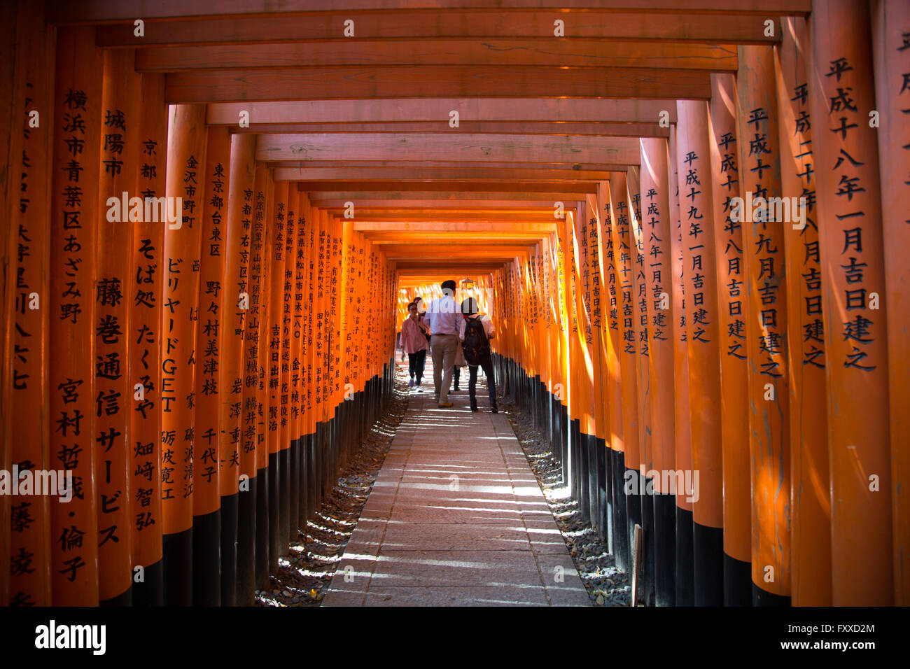 Menschen zu Fuß durch die markante orangenen Bögen der Fushimi Inari-Schrein in Kyōto, Japan. Stockfoto