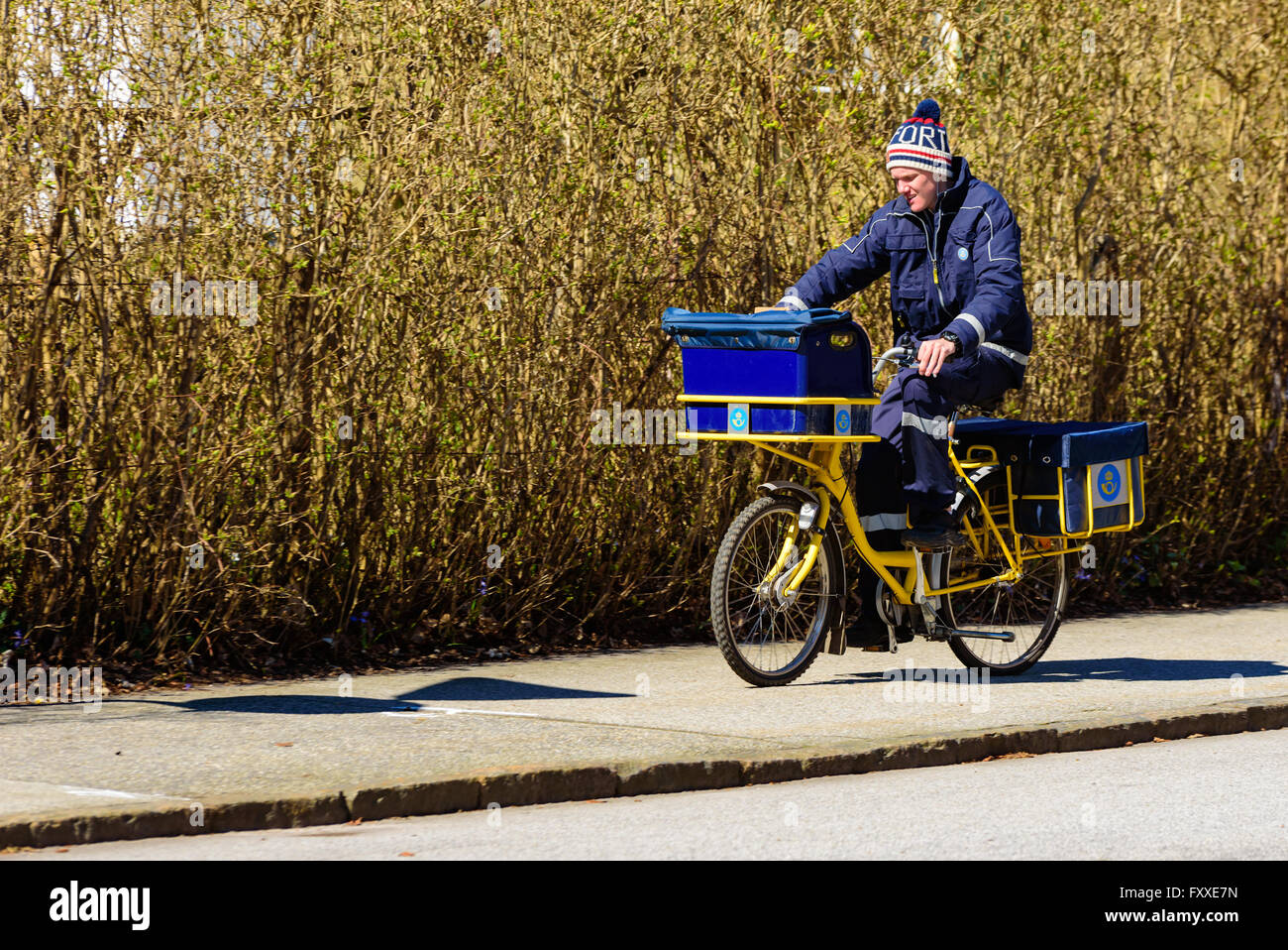 Lund, Schweden - 11. April 2016: Echtes Leben in der Stadt. Junge männliche Postbote seine Runde auf dem Fahrrad zu tun. Stockfoto