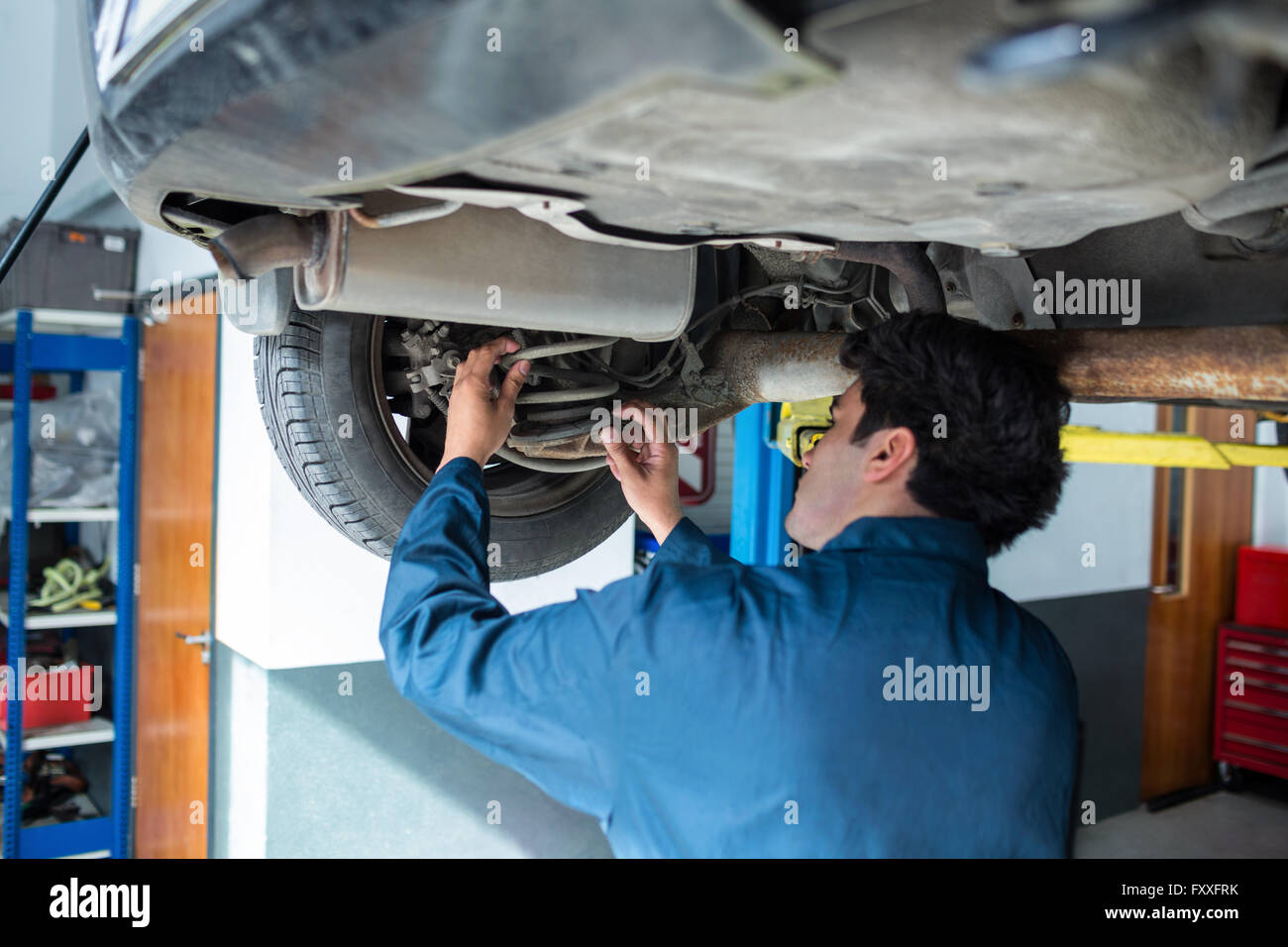 Mechaniker, die Federung eines Autos zu reparieren Stockfoto