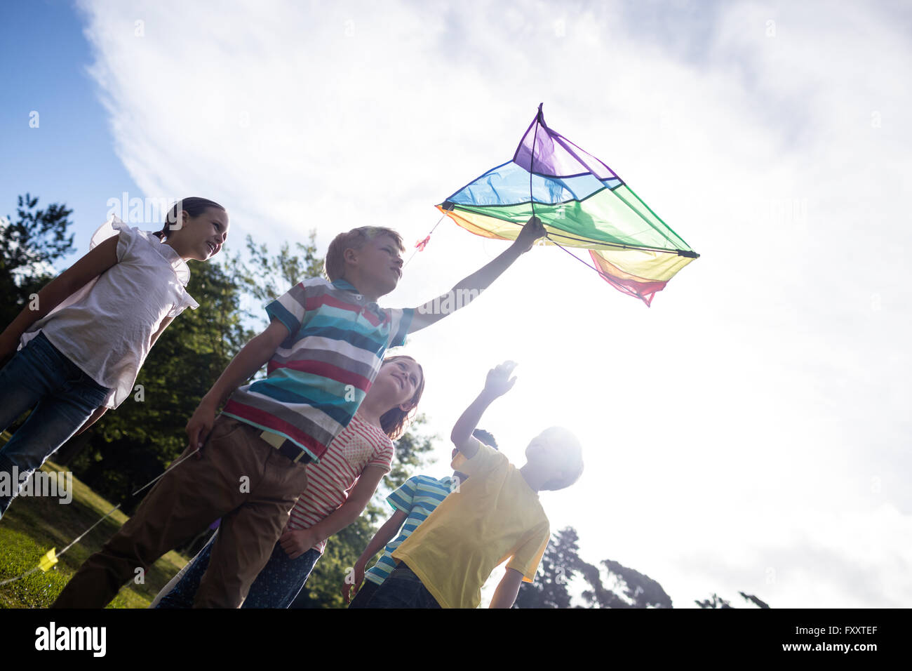 Glückliche Kinder spielen mit einem Drachen Stockfoto