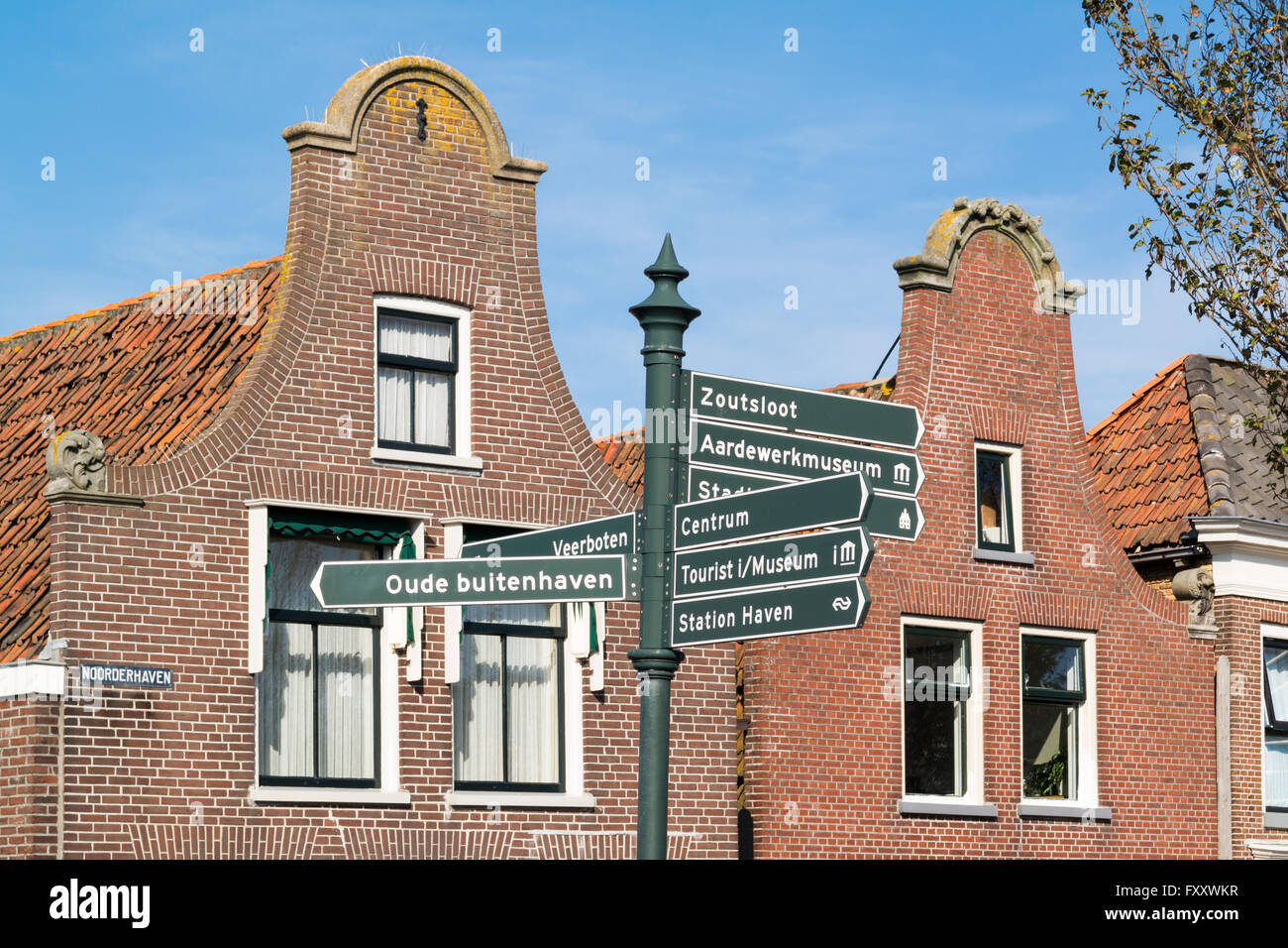 Uhr-Giebel der Häuser und Wegweiser in der historischen alten Stadt von Harlingen, Friesland, Niederlande Stockfoto