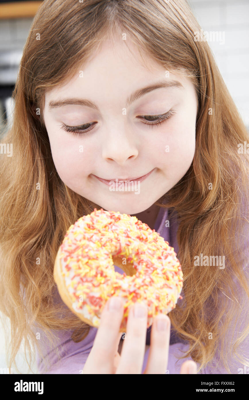 Junges Mädchen essen zuckerhaltige Donut für Snack Stockfoto