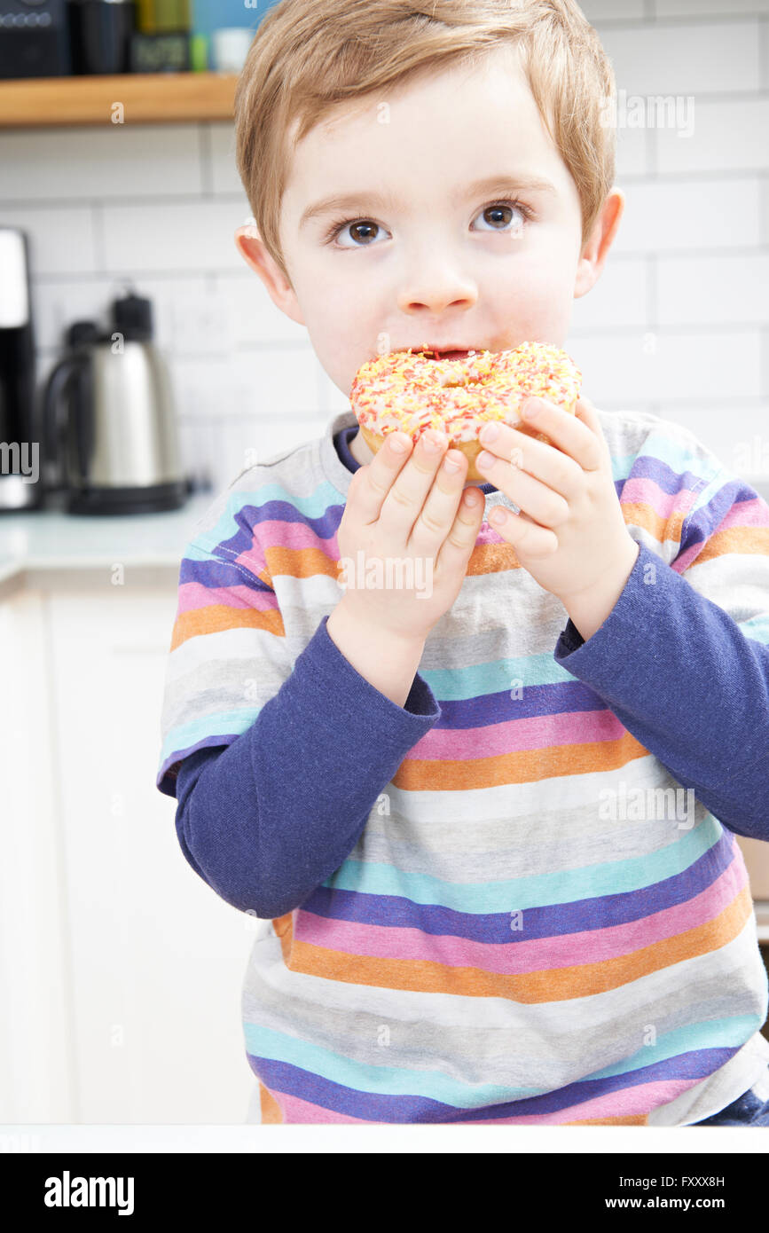 Kleiner Junge zuckerhaltige Donut für Snack Essen Stockfoto