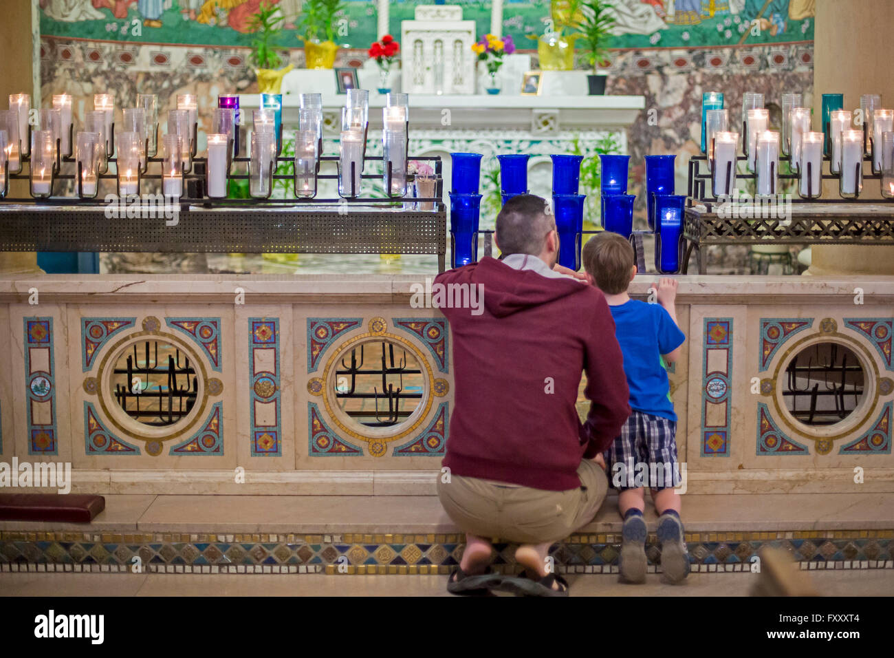 Detroit, Michigan - ein Mann und sein Sohn untersuchen die Votiv-Kerzen, vor Beginn der Messe in der Erlöser, Heilige, katholische Kirche. Stockfoto