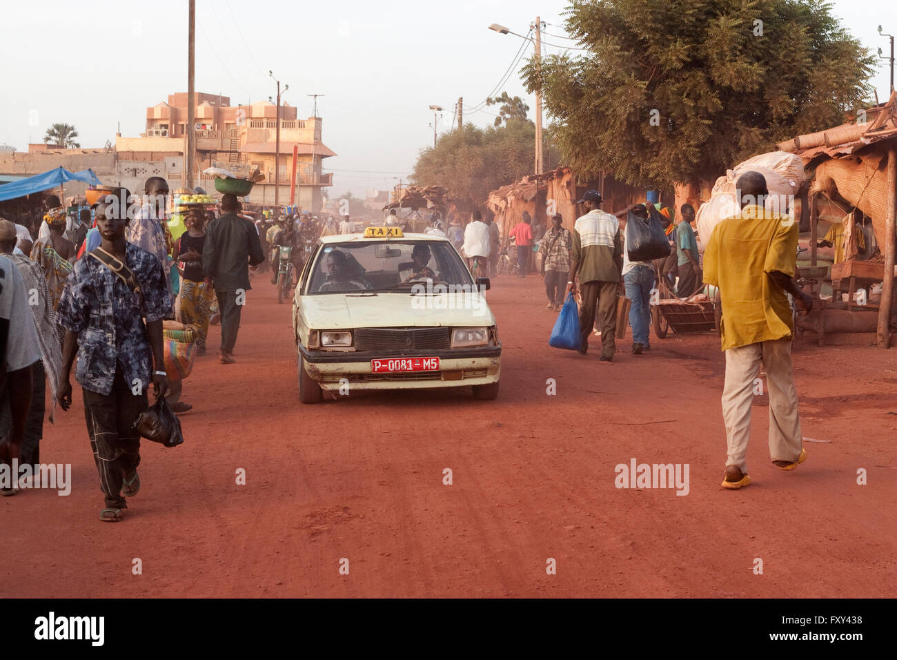 Ein Auto überquert den Markt auf eine unbefestigte Straße in Mopti, Mali Stockfoto