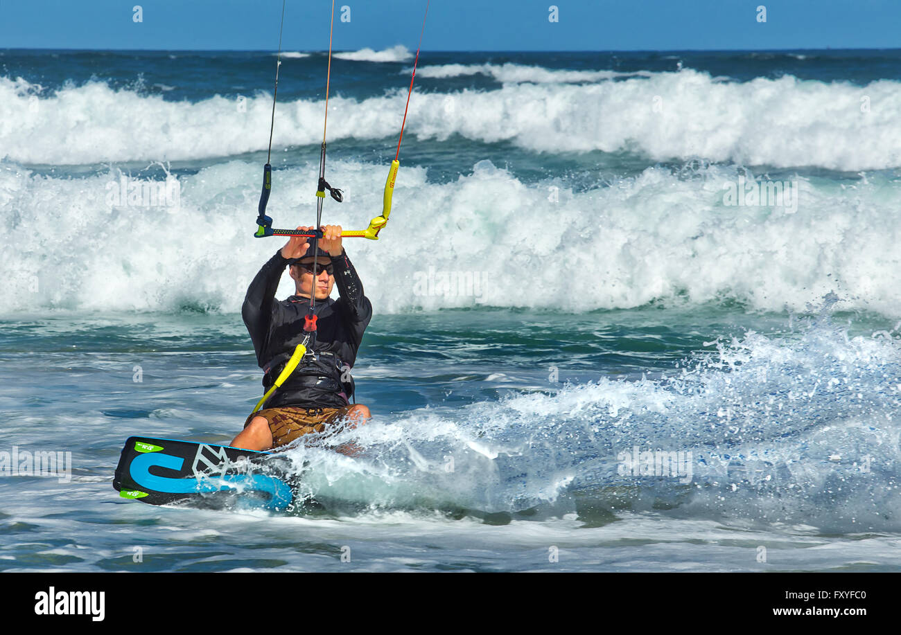 Eine Kitesurfer genießt die Wellen aus den Nobby Beach, Newcastle, Australien. Stockfoto