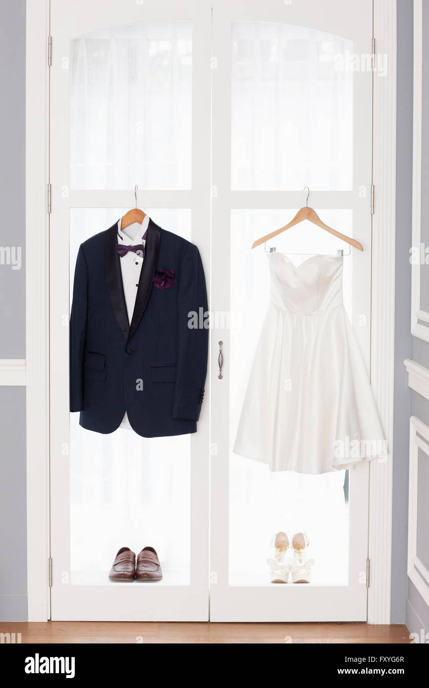 Smoking und Hochzeit Kleid mit Schuhen an den Fenstern aufgehängt Stockfoto