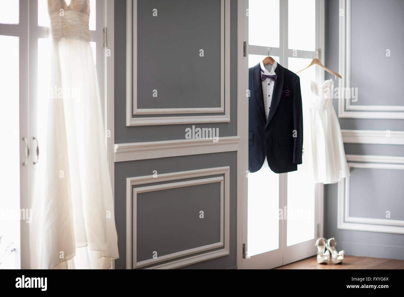 Smoking und zwei Brautkleider hingen bis auf Windows und high heels Stockfoto