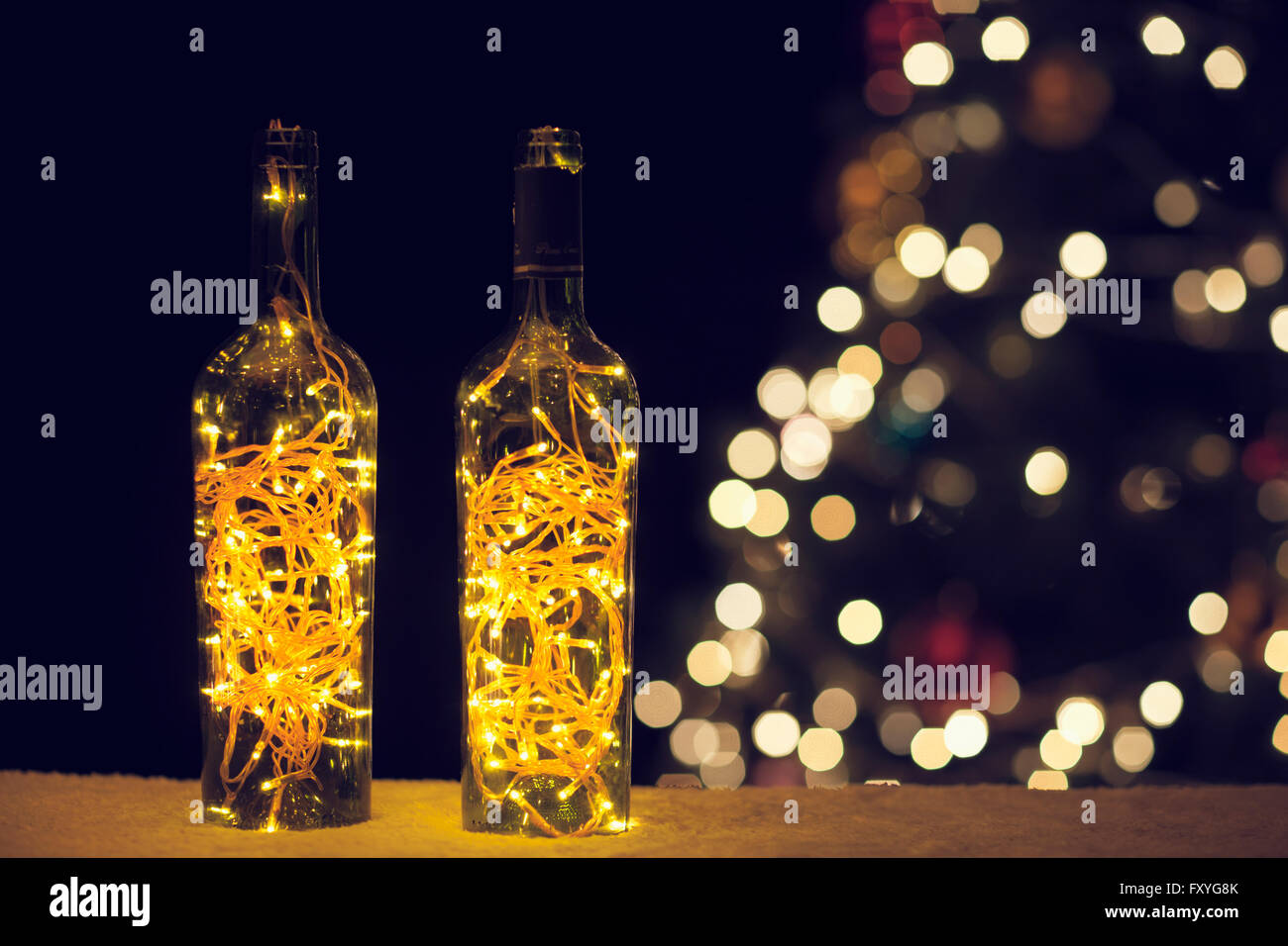 Weine in Flaschen gefüllt mit gold-glitzernde Lampen Stockfoto