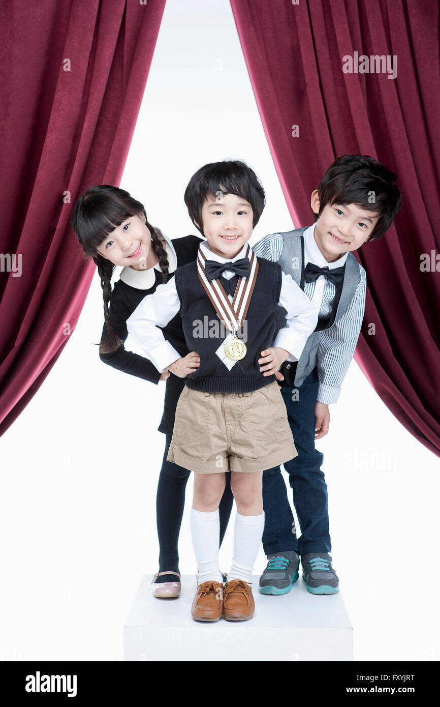 Drei Kinder mit Gold Medaille zusammen stehen vor Vorhänge Stockfoto