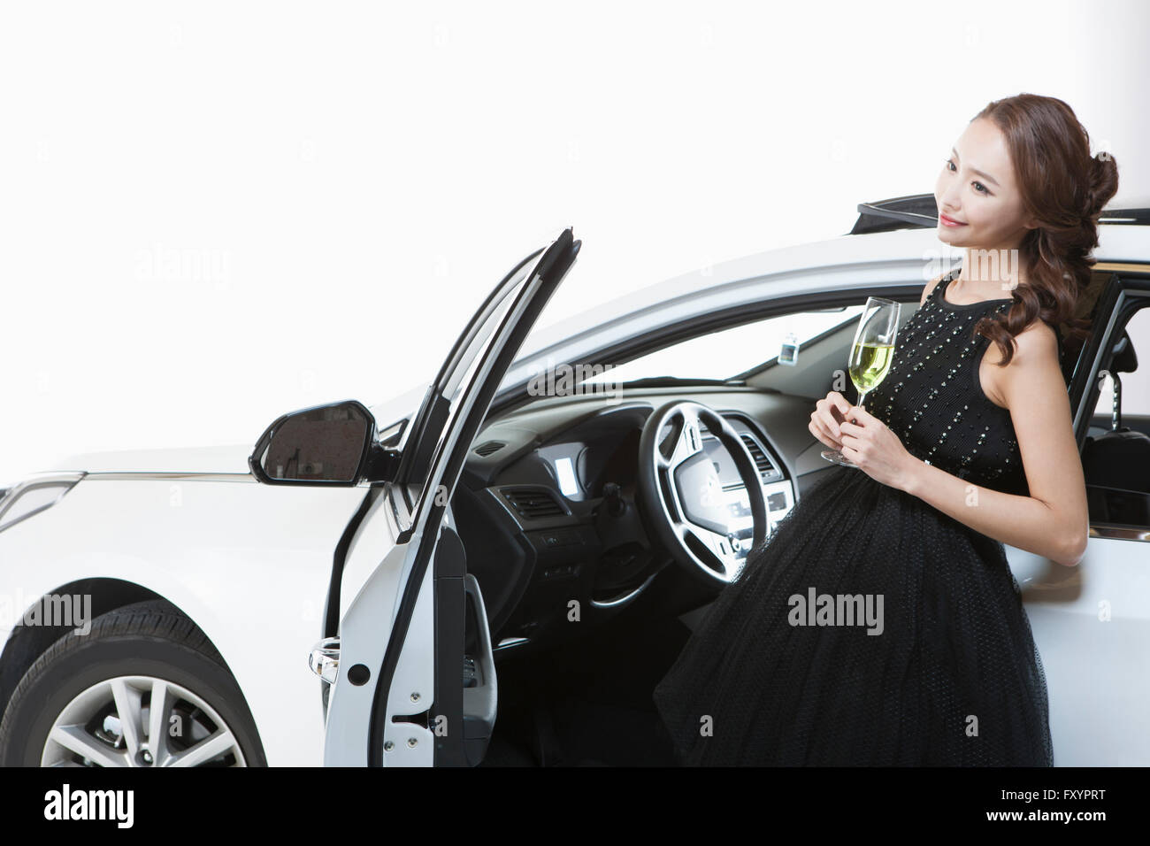 Seitenansicht des jungen lächelnde Frau hält einen Glas Champagner im offenen Wagen Stockfoto