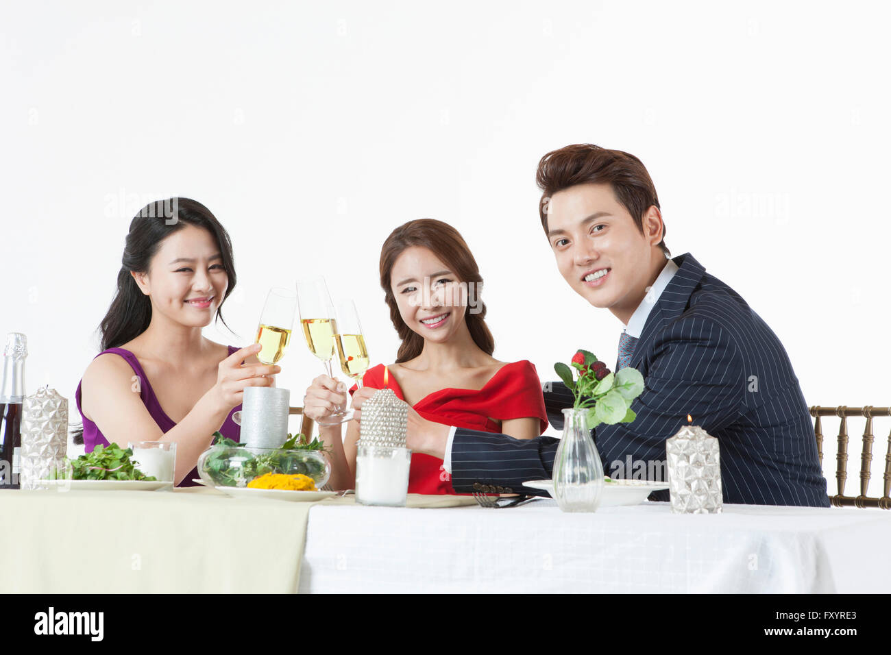 Seite Ansicht Porträt der jungen lächelnde Menschen hält Champagner Gläser am Tisch Stockfoto