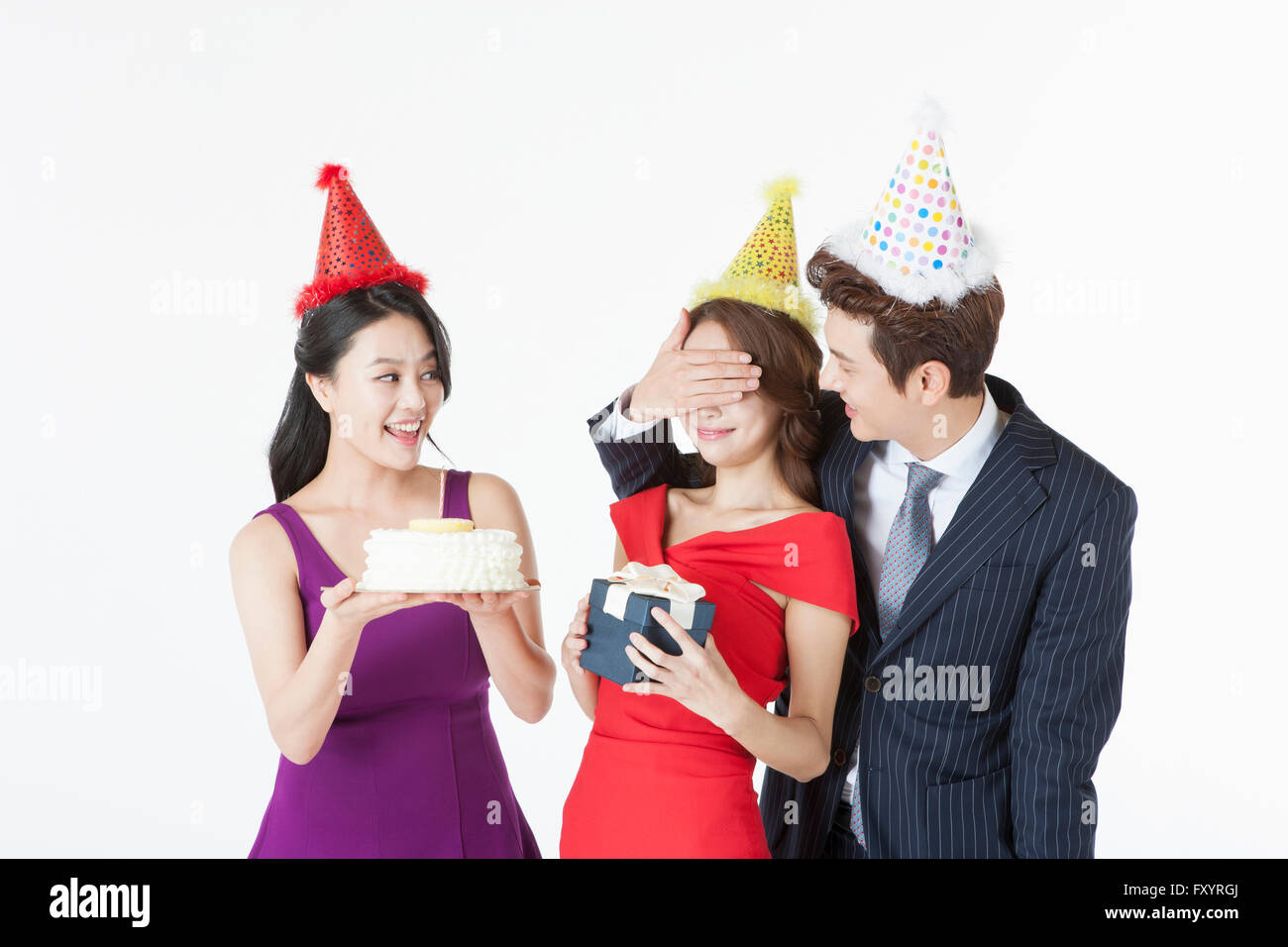 Porträt von drei Jugendlichen mit einem Kuchen und eine Überraschung auf party Stockfoto