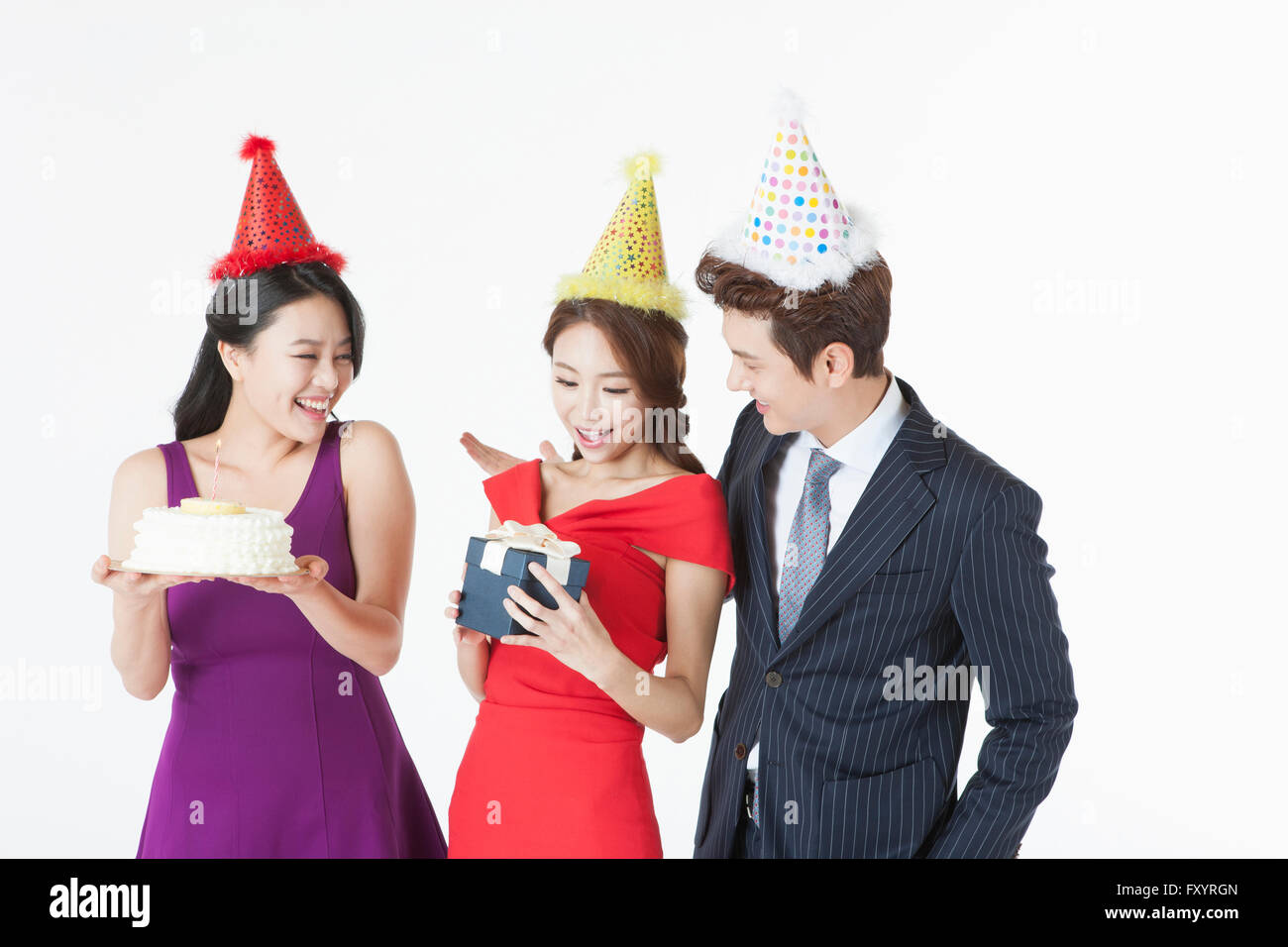 Porträt von drei jungen Leuten mit einer Torte und einer Geschenkbox auf party Stockfoto