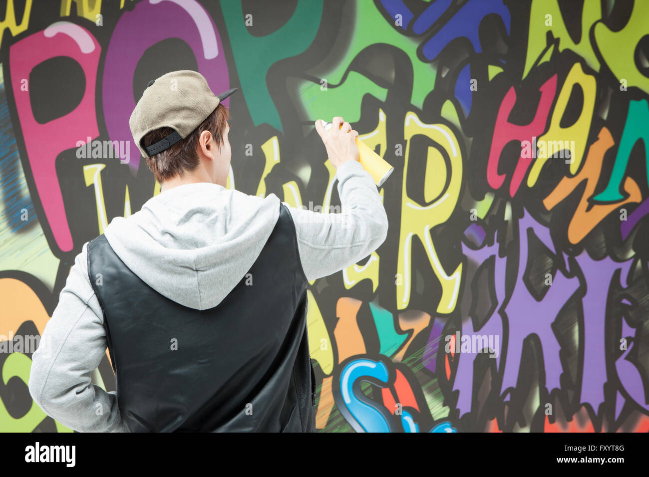 Porträt des jungen Mannes im Hip-Hop-Stil mit einem Spray gegen Graffiti-Kunst zurück Stockfoto