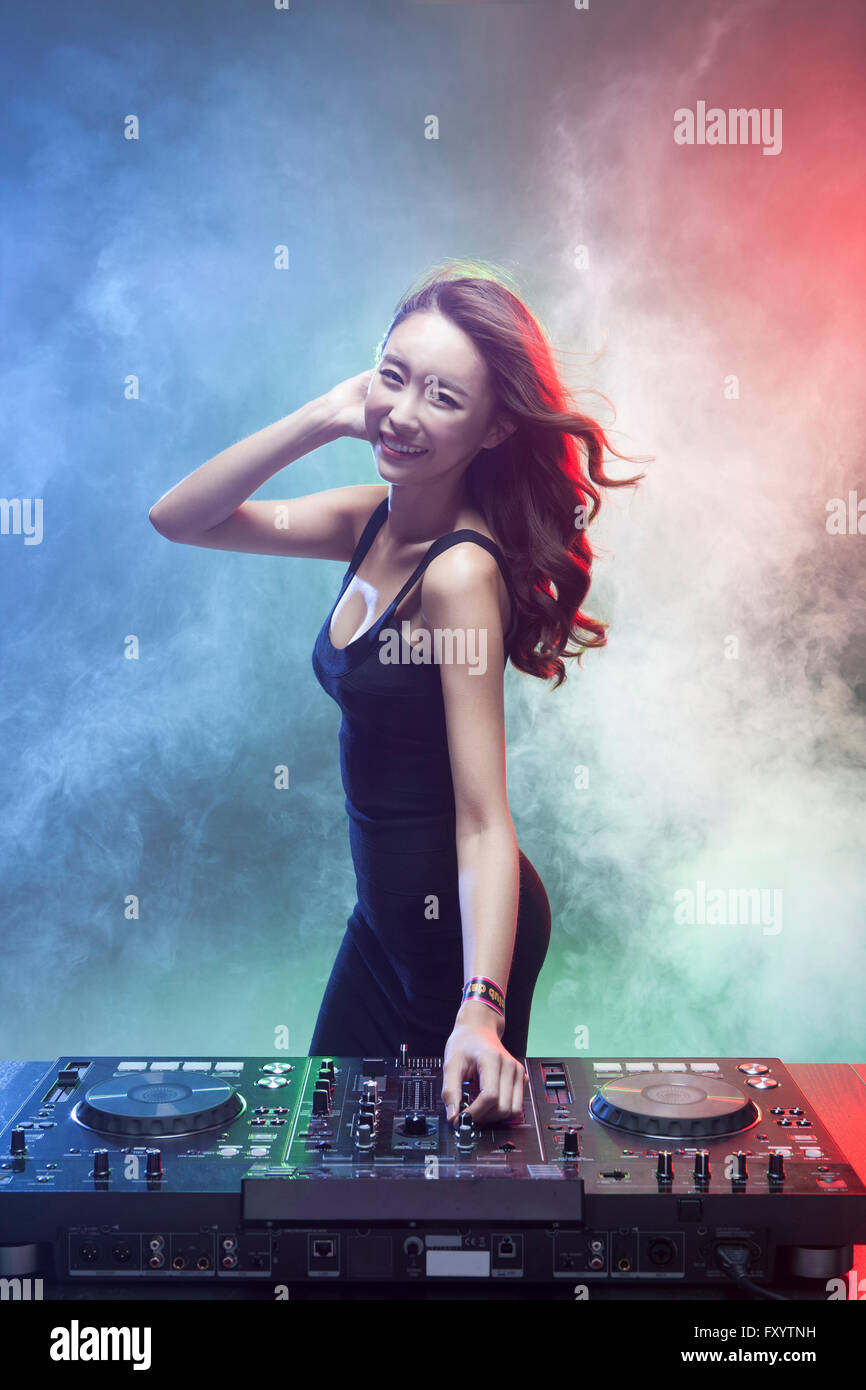 Seite Ansicht Porträt der jungen weiblichen DJ spielt Musik vorne starrte lächelnd Stockfoto
