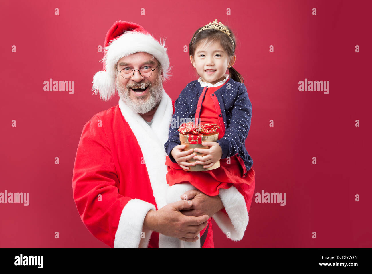 Porträt von lächelnden Weihnachtsmann und ein Mädchen mit einer Geschenkbox starrte auf Vorderseite Stockfoto