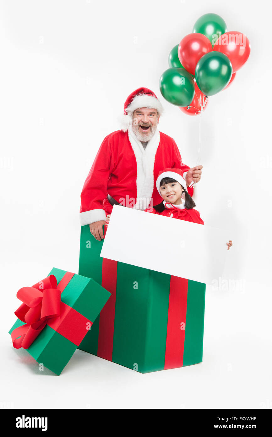 Porträt von Santa und Mädchen hält Luftballons lächelnd an Front in eine große Geschenkbox Stockfoto