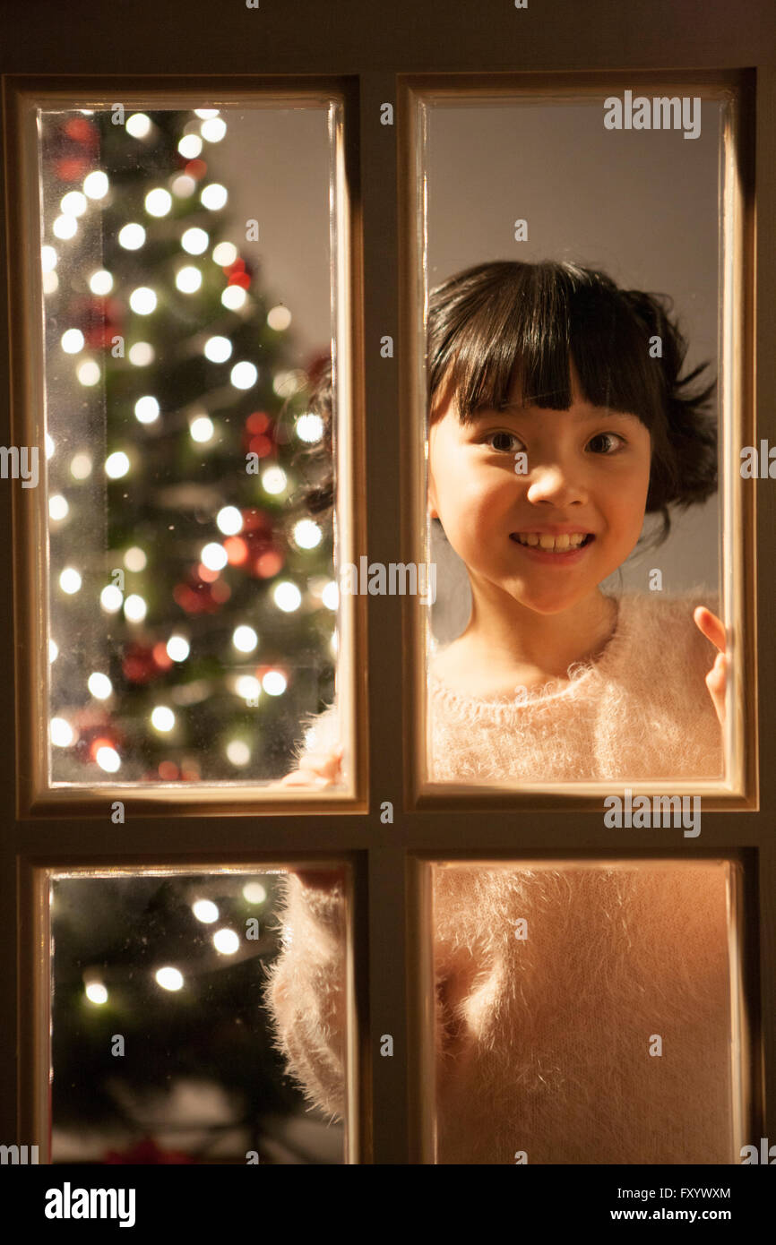 Porträt eines lächelnden Mädchens Blick aus Fenster Stockfoto