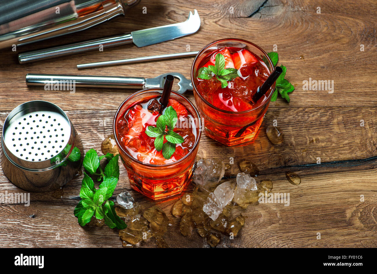 Rotes Getränk mit Erdbeere, Minze Blätter, Eis. Shaker und cocktail-Bar-Werkzeuge Stockfoto