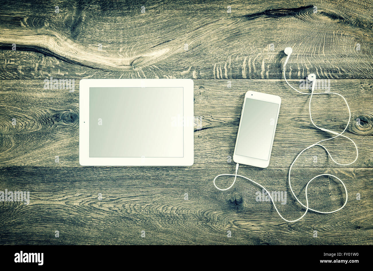 Digitale Geräte. Smartphone mit Kopfhörern und tablet-pc. Vintage-Stil getönten Bild Stockfoto
