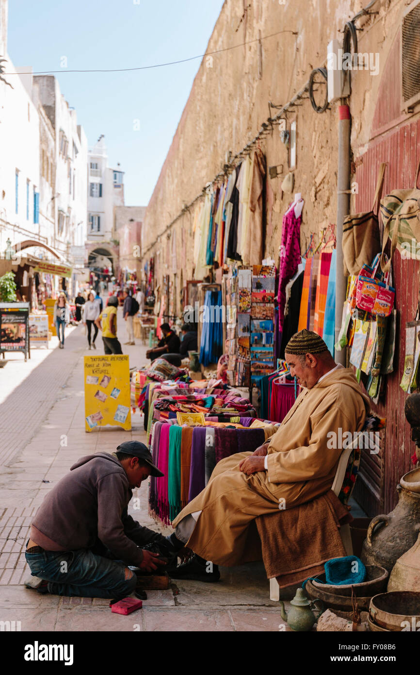 Ein marokkanischer Mann hat seine Schuhe glänzte in der Medina von Essaouira, eine berühmte Hafenstadt an der Ostküste von Marokko Stockfoto