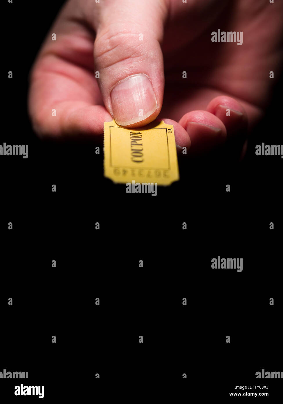 Ein Mann rechten Hand ein gelbes 7-stellige Ticket gekennzeichnet mit dem Wort "Gutschein" in schwarzer Tinte gedruckt Stockfoto