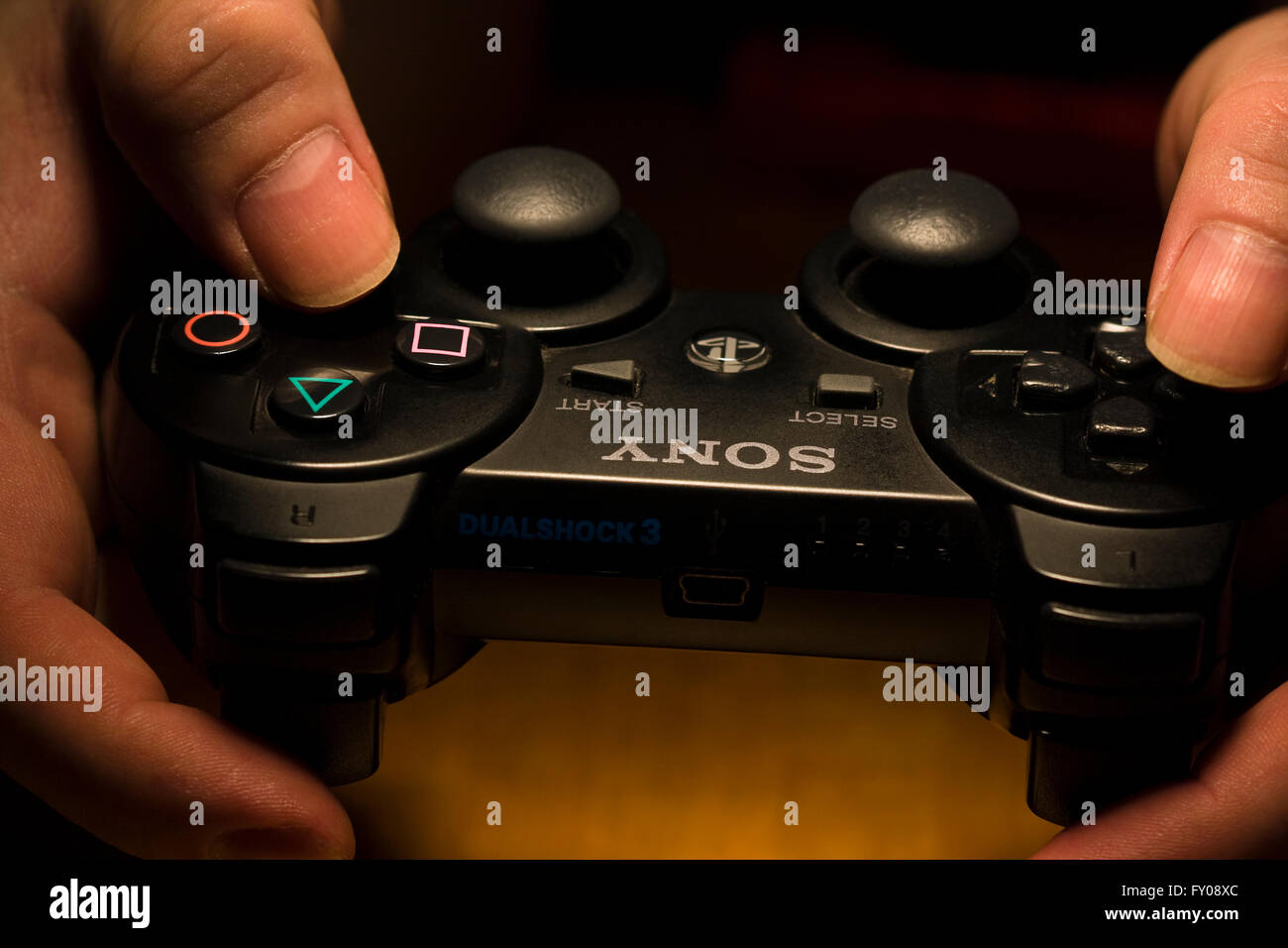 Zwei Hände halten ein drahtloses SONY Playstation Dual Shock 3 Controller Stockfoto