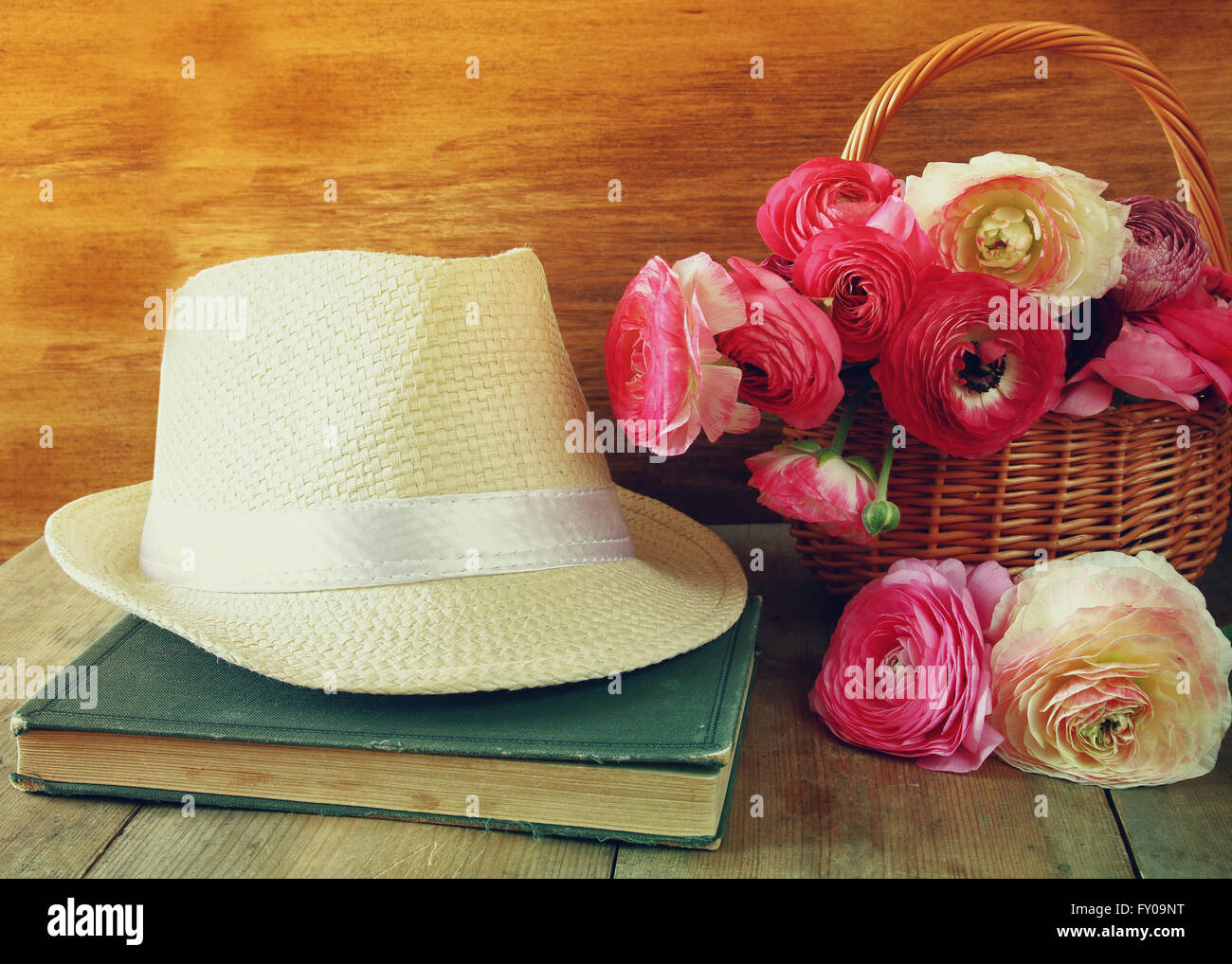 Fedora-Hut neben altes Buch und Blumen auf Holztisch. Jahrgang gefiltert und getönten Stockfoto