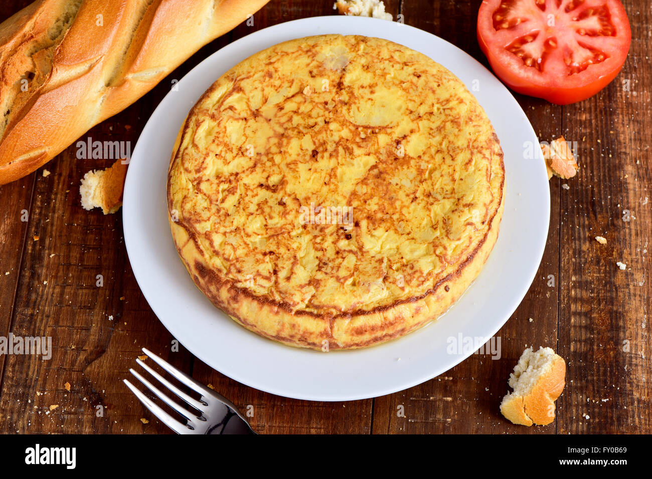 Nahaufnahme einer Platte mit einer typischen Tortilla de Patatas, ein spanisches Omelett auf einem dunklen Holztisch Stockfoto