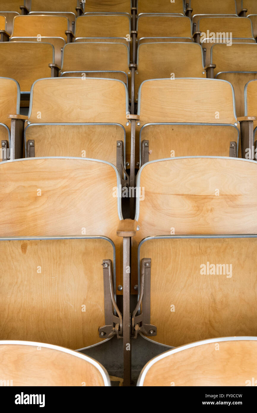 Leere hölzerne Universität Aula Klappsitze in einem leeren Klassenzimmer Stockfoto