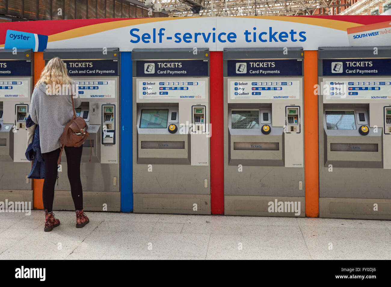 Bahnpassagiere am Selbstbedienungsautomat am Bahnhof London Waterloo, London England Großbritannien Stockfoto