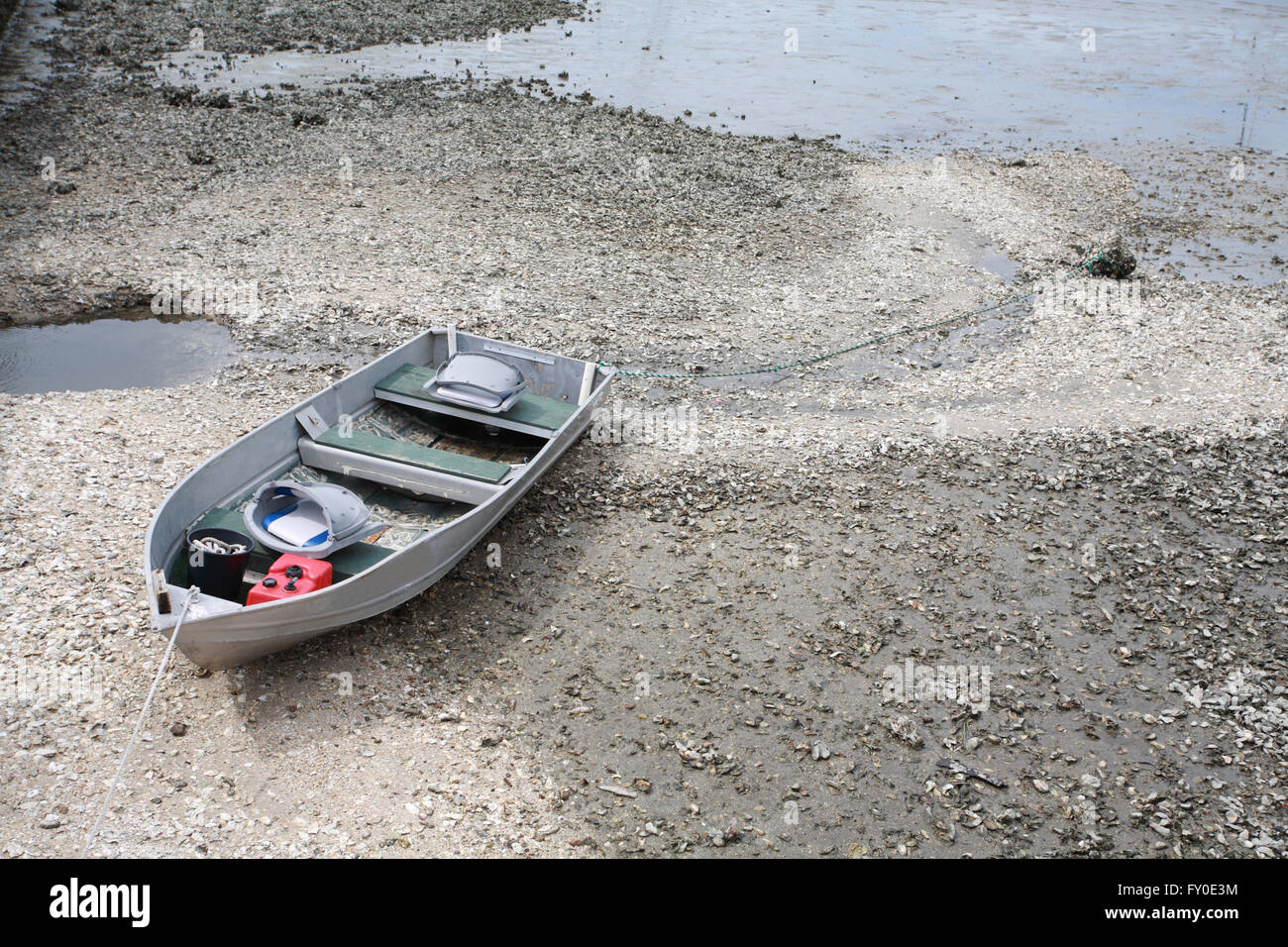 Ein altes Aluminium Boot gebunden an einen Felsen am Ufer atlantischen Meeres. Im Inneren des Bootes ist eine rote Kunststoff Benzin oder Benzin tan Stockfoto
