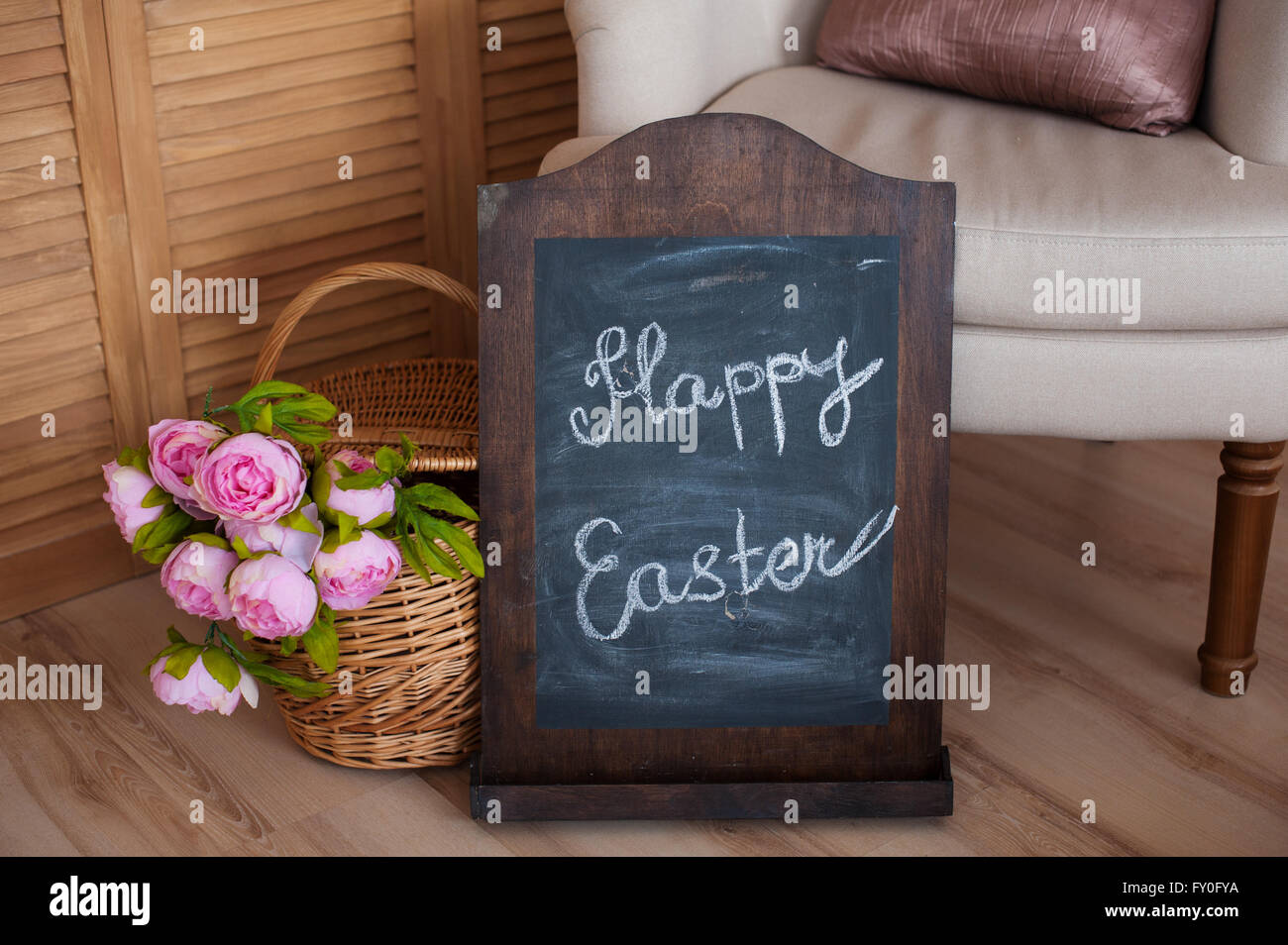 Blumenstrauß in einem Korb und Frohe Ostern an Tafel Stockfoto