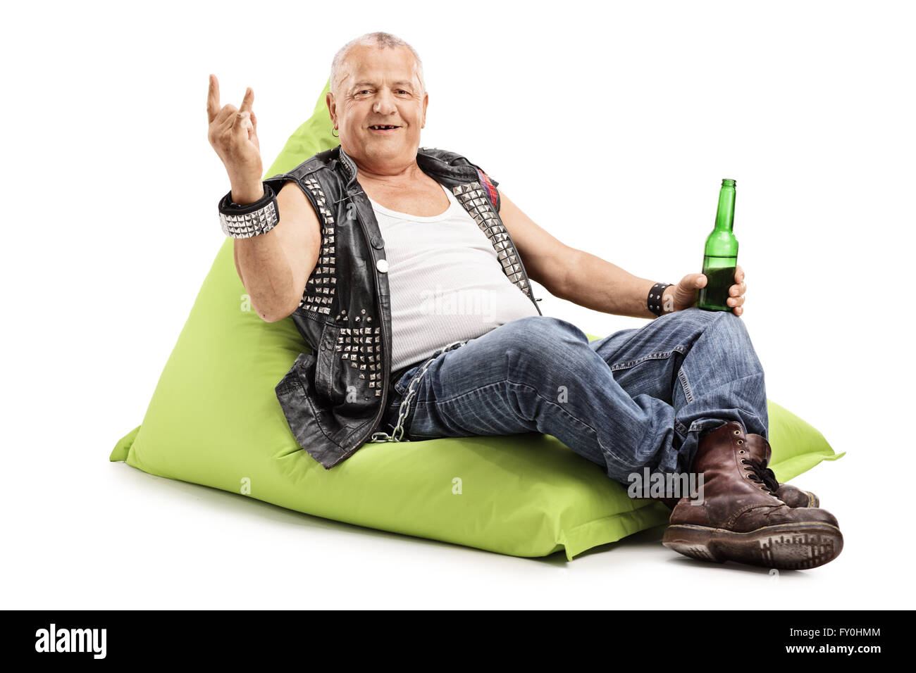 Reife Punkrocker Biertrinken sitzt auf einem Sitzsack und eine Rock Hand Geste isoliert auf weißem Hintergrund Stockfoto
