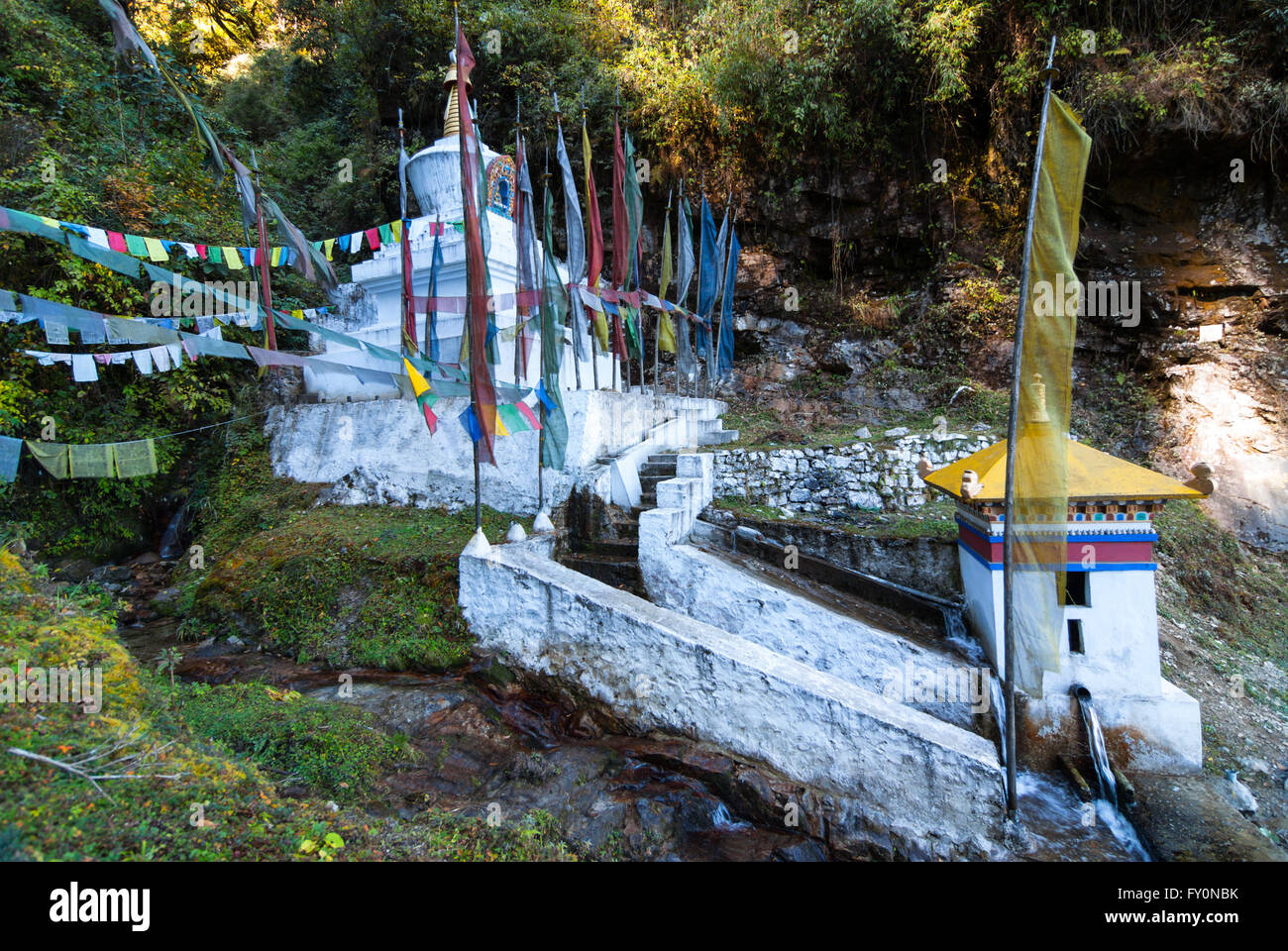 Wasser-gedrehte Gebetsmühle und Stupa neben Straße zwischen Dochu La und Metshina im westlichen Bhutan Stockfoto