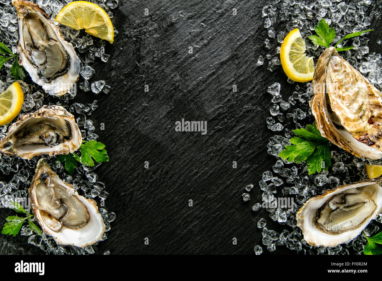 Austern auf Steinplatte serviert mit Eisgang Stockfoto