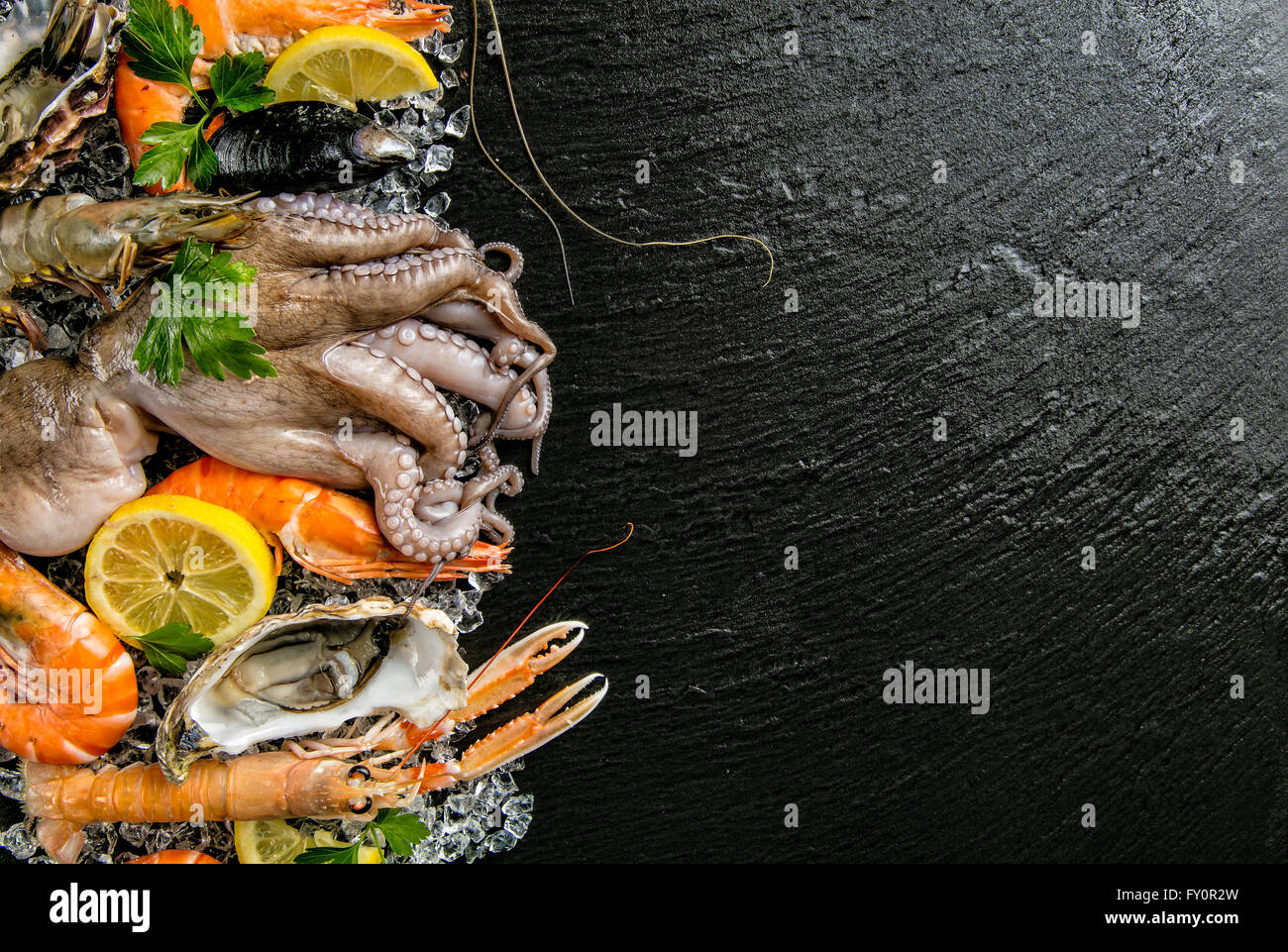 Meeresfrüchte serviert auf schwarzem Stein Stockfoto