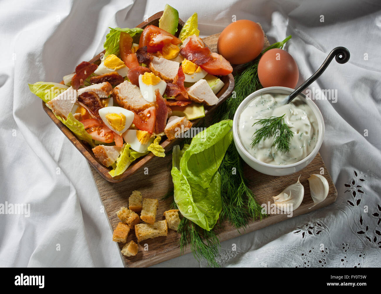 Cobb Salat, mit Ei, Speck und Huhn. Serviert mit einer Seitenlänge von Buttermilch und Dilldressing. Stockfoto