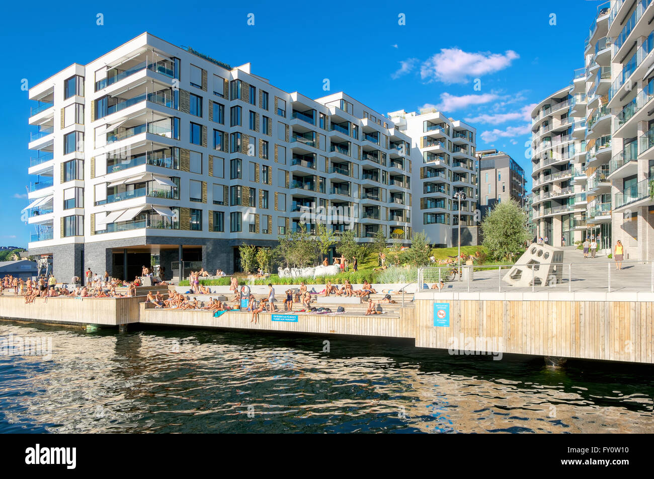 OSLO, Norwegen - 13 AUGUST: Umwelt im modernen Stadtteil mit Sonnenbaden Jugendlichen am künstlichen Strand in warmen Tag am 13. August Stockfoto